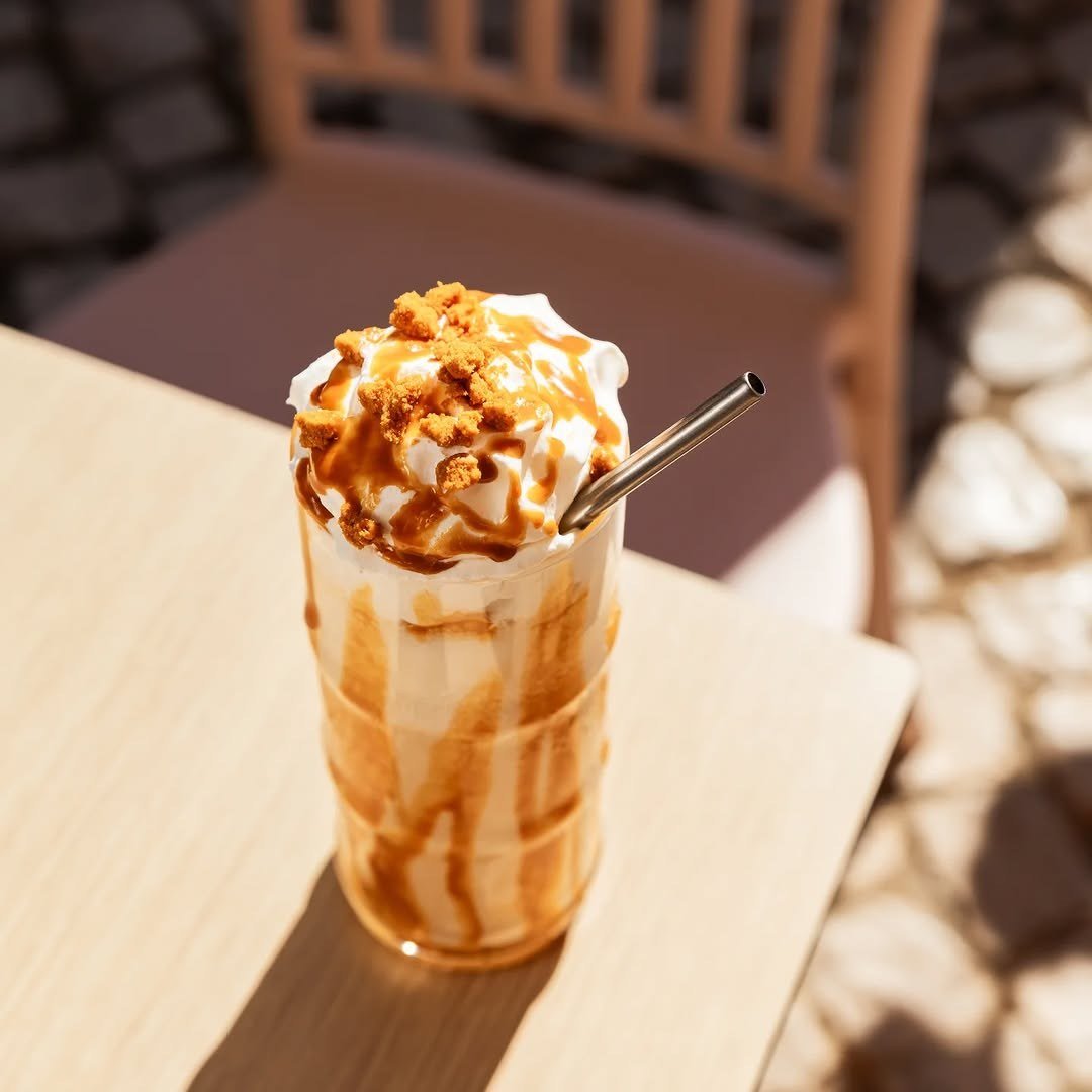 Copo alto de milkshake com natas, bolacha esmigalhada e caramelo a escorrer